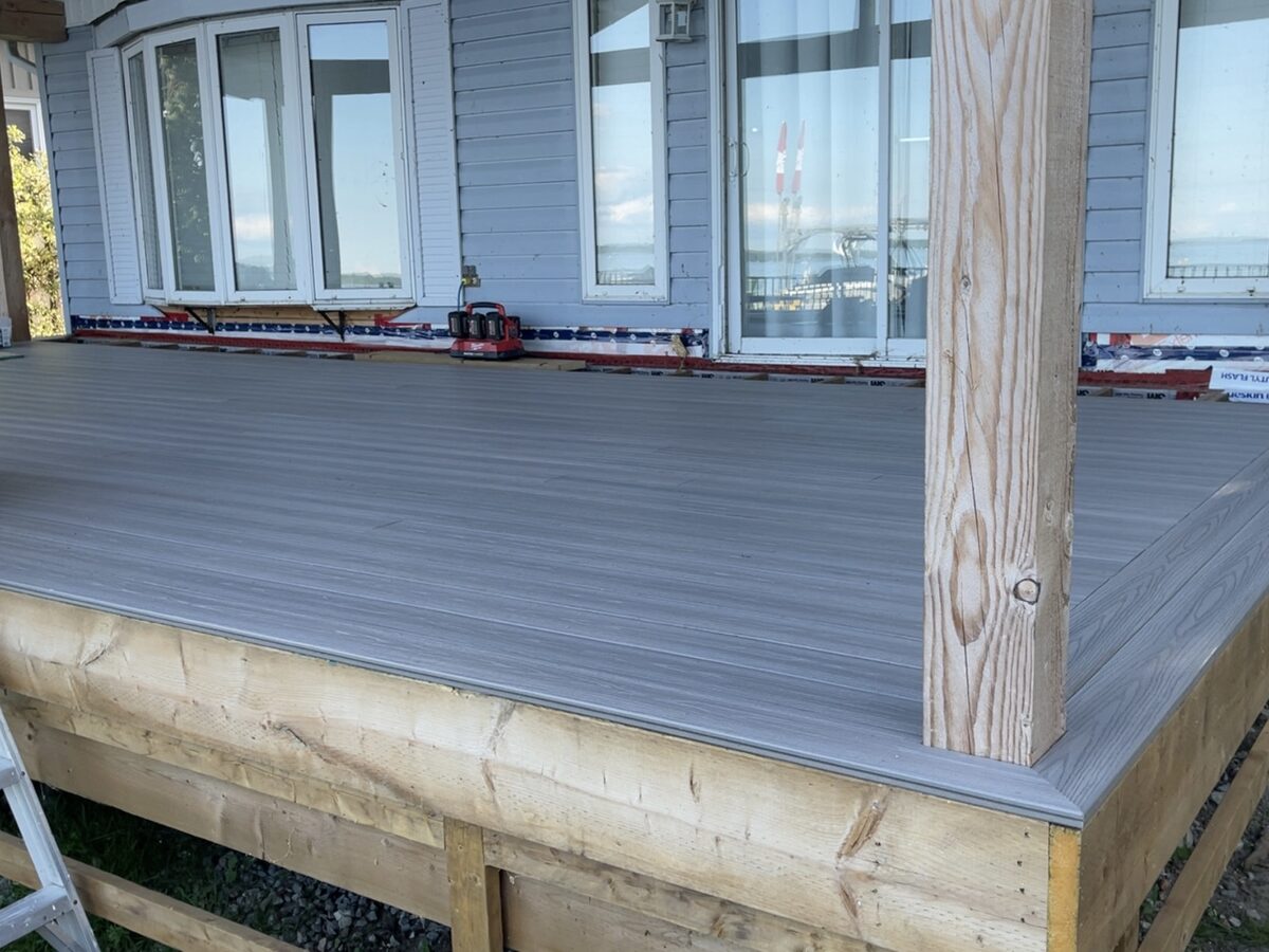 Raised composite deck build beside a home